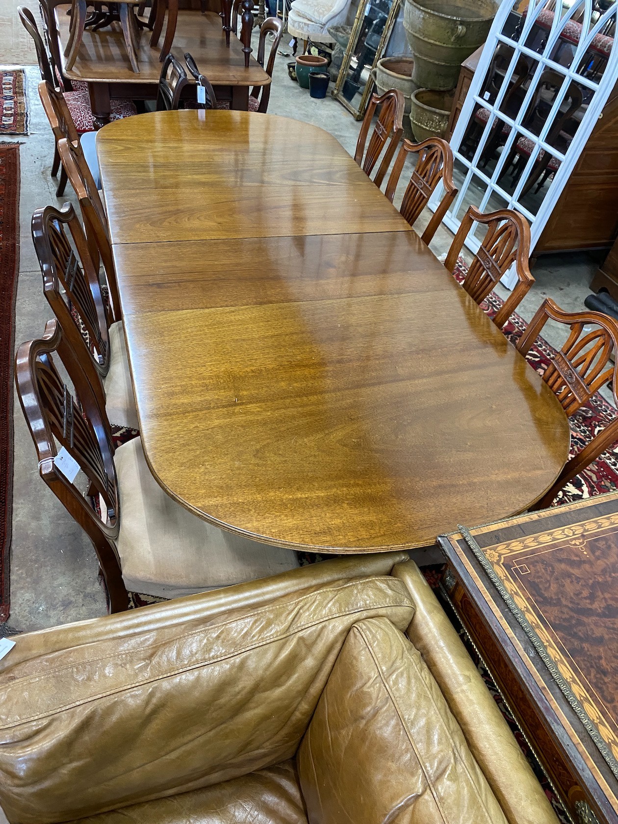 A William Tillman reproduction mahogany twin pedestal extending dining table, length 244cm extended, two spare leaves, depth 102cm, height 72cm and eight shield back dining chairs